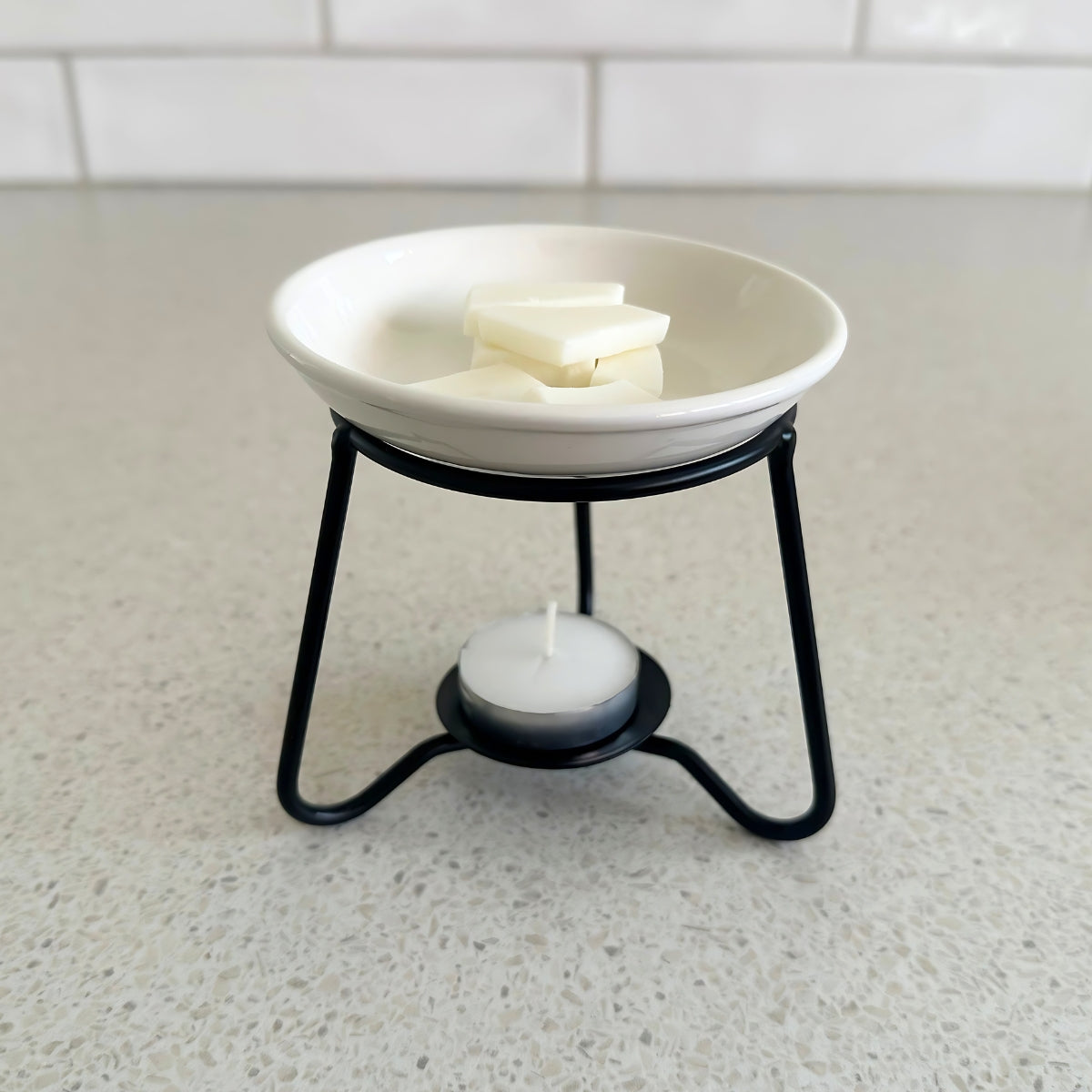 tealight wax warmer with black metal base and removable ceramic dish